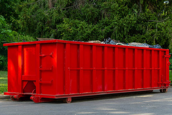 A large iron dumpster in White Plains, NY, for outdoor steel metal trash is full and needs to be emptied.