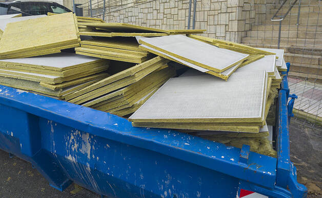 A dumpster in White Plains, NY, is full of glass wool slabs from a construction project.