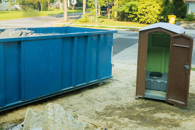 In White Plains, NY, a construction garbage dumpster and portable restroom are set up at a new house under construction site.