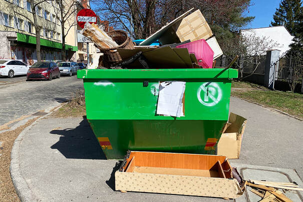 A metal container overflowing with waste is seen up close in White Plains, NY.