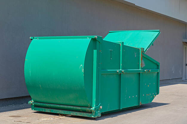 White Plains, NY, a big green press container compacts industrial waste.