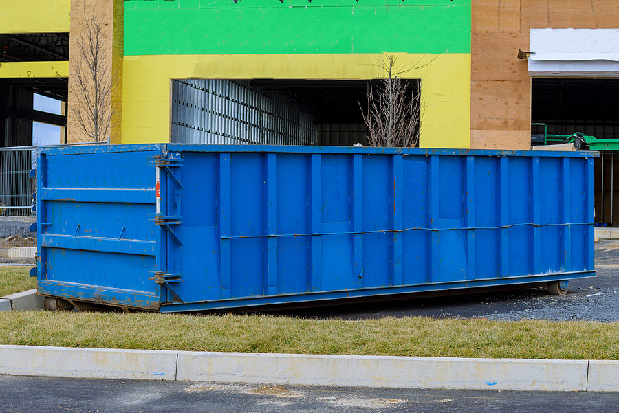 At the construction site in White Plains, NY, a big iron dumpster is used for junk recycling.