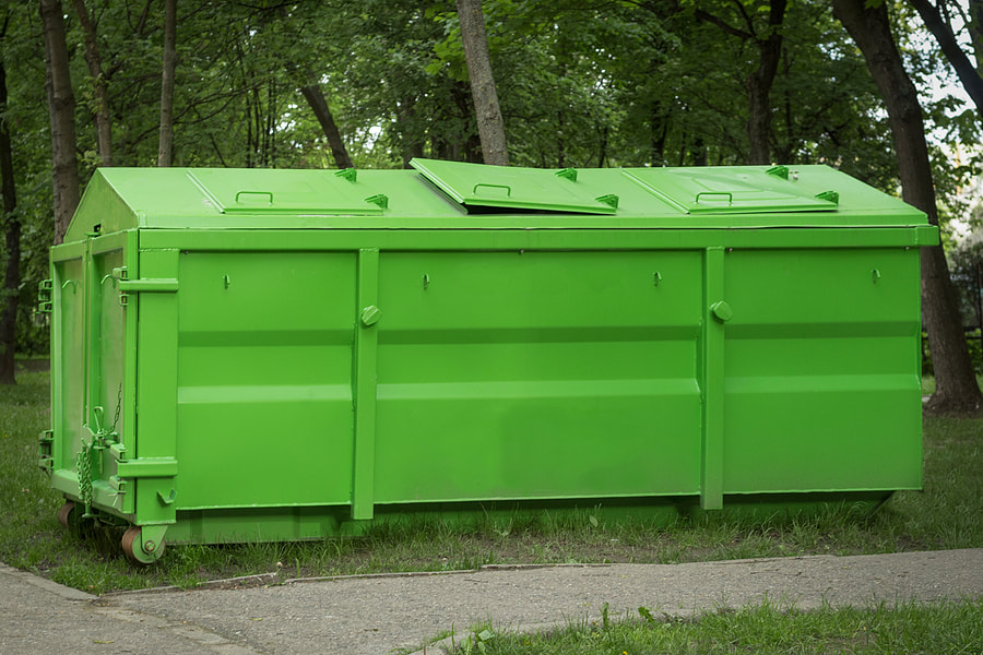 A covered metal container with a lid is used for construction and household waste in White Plains, NY.